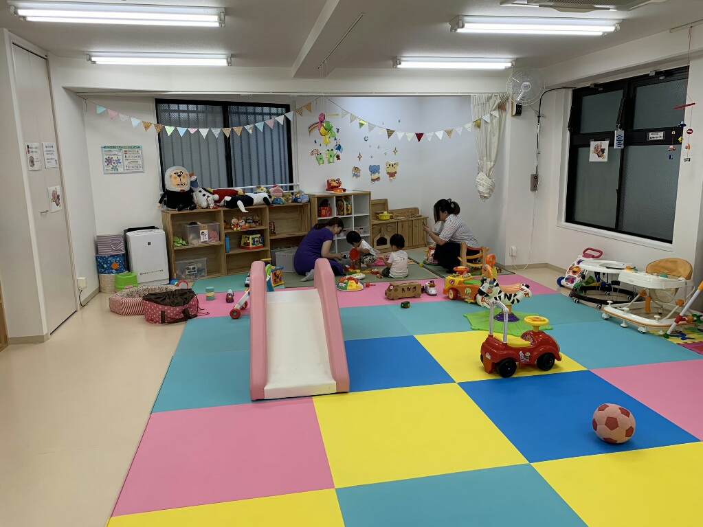 カラフルで可愛いプレイマットにドーンと置かれているピンクの滑り台